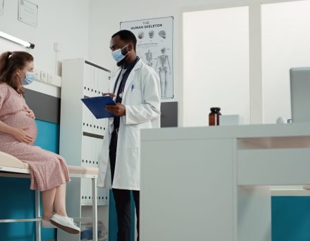 doctor and pregnant woman with face mask attending checkup visit doctor and pregnant woman with face mask attending checkup visit